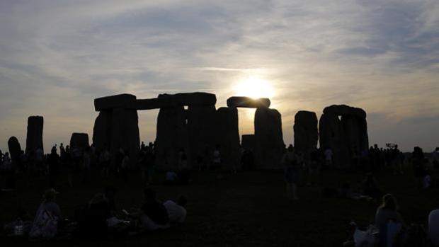 El sol sale tras el monumento de Stonehenge, conocido como «El Templo del Sol», durante el festival del Solsticio de Verano, en Reino Unido