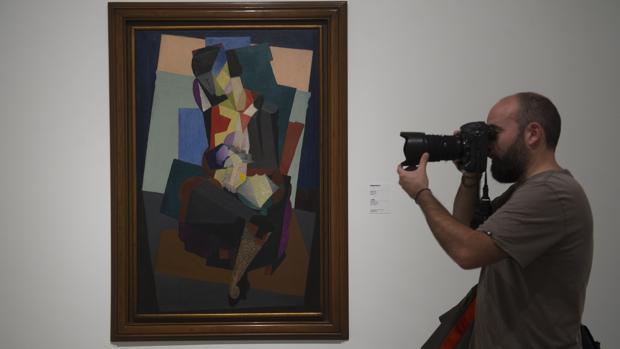Un fotógrafo toma una imagen de una de las obras de la exposición