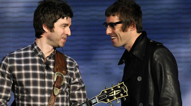 Los hermanos Gallagher, de Oasis, sonriéndose en medio de un concierto