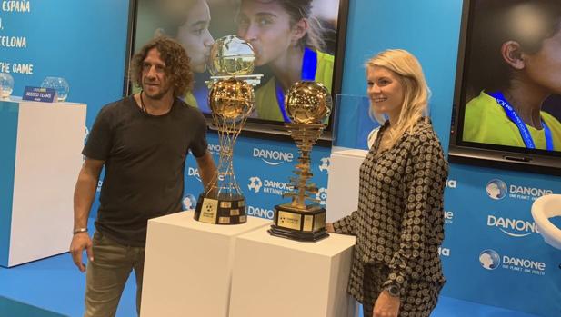Carles Puyol y Ada Hegerberg con los trofeos de la Danone Nations Cup