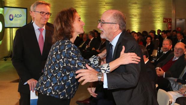 La ministra Teresa Ribera saluda al presidente de Repsol, Antonio Brufau, con el presidente de BP, Luis Aires, como testigo, al comienzo del acto