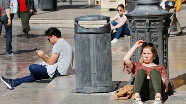 Imagen de una joven tomando el sol en centro de valencia debido al calor extremo