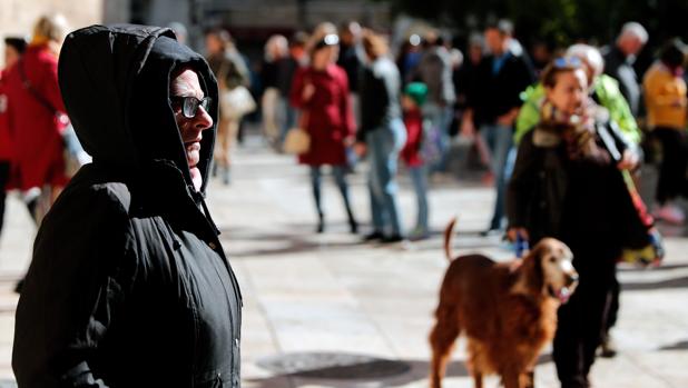 Una mujer se protege del frío en una imagen captada en el centro de Valencia