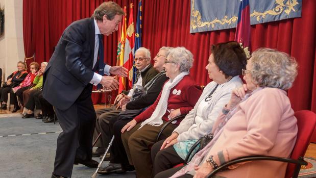 El consejero De Santiago-Juárez saluda a los «niños de la guerra» homenajeados en la Universidad de Burgos