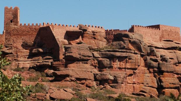 Silueta del castillo de Peracense, mimetizado con la rojiza mole de roca sobre la que se asienta
