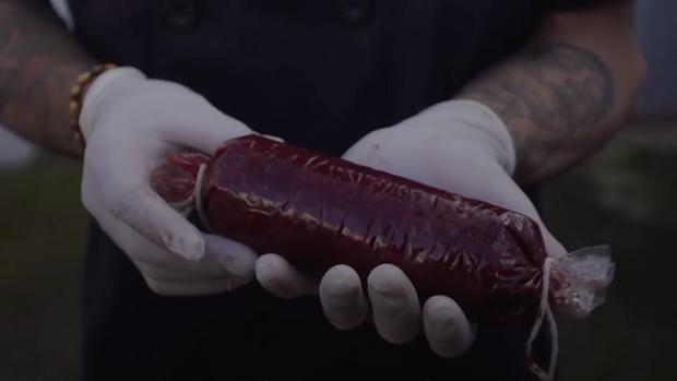 El joven Raúl Escuín muestra una morcilla que ha elaborado con su propia sangre