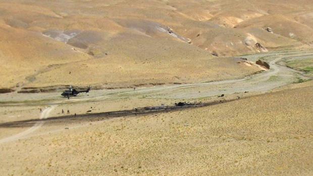 Vista de los restos del helicóptero "Cougar", que se estrelló en Afganistán cuando participaba en una operación de integración de las Fuerzas Armadas españolas, en el que fallecieron diecisiete militares españoles. A la izquierda el helicóptero medicalizado que acudió al lugar de los hechos