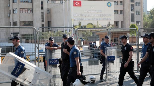 Agentes de la Policía turca caminan frente a la sede municipal de Diyarbakir, hoy