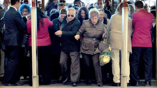Un nutrido grupo de personas entra en unos grandes almacenes del centro de Barcelona en el instante de abrir las puertas y dar comienzo a las rebajas de invierno