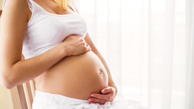 Una mujer muestra su barriga de embarazada